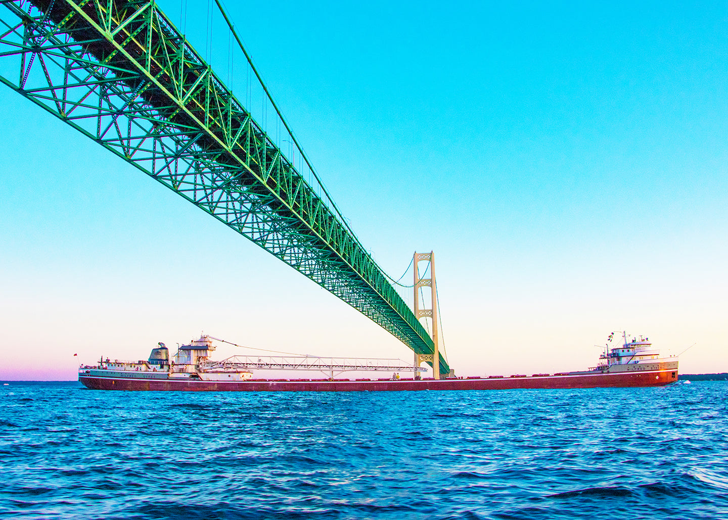This unique perspective of a freighter traveling beneath the Mackinac Bridge by Jennifer Wohletz of Mackinac Memories evokes a sense of wonder at the bridge's strength and regional importance. The Mighty Mac spans across the Great Lakes to connect Michigan's upper and lower peninsulas.