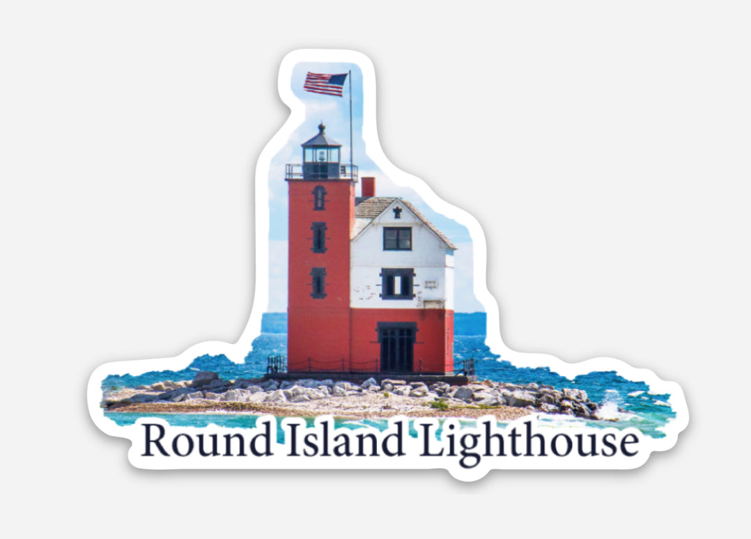This die cut vinyl sticker features a photo of Round Island Lighthouse with the American flag waving on a beautiful sunny day. The lighthouse is located near Mackinac Island, Mich.