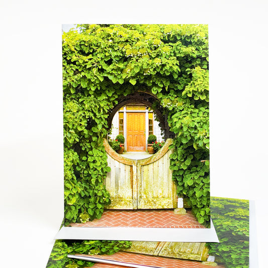 Blank greeting card featuring a photograph of a Mackinac Island cottage gate covered in geranium blooms by Michigan artist Jennifer Wohletz of Mackinac Memories.  
